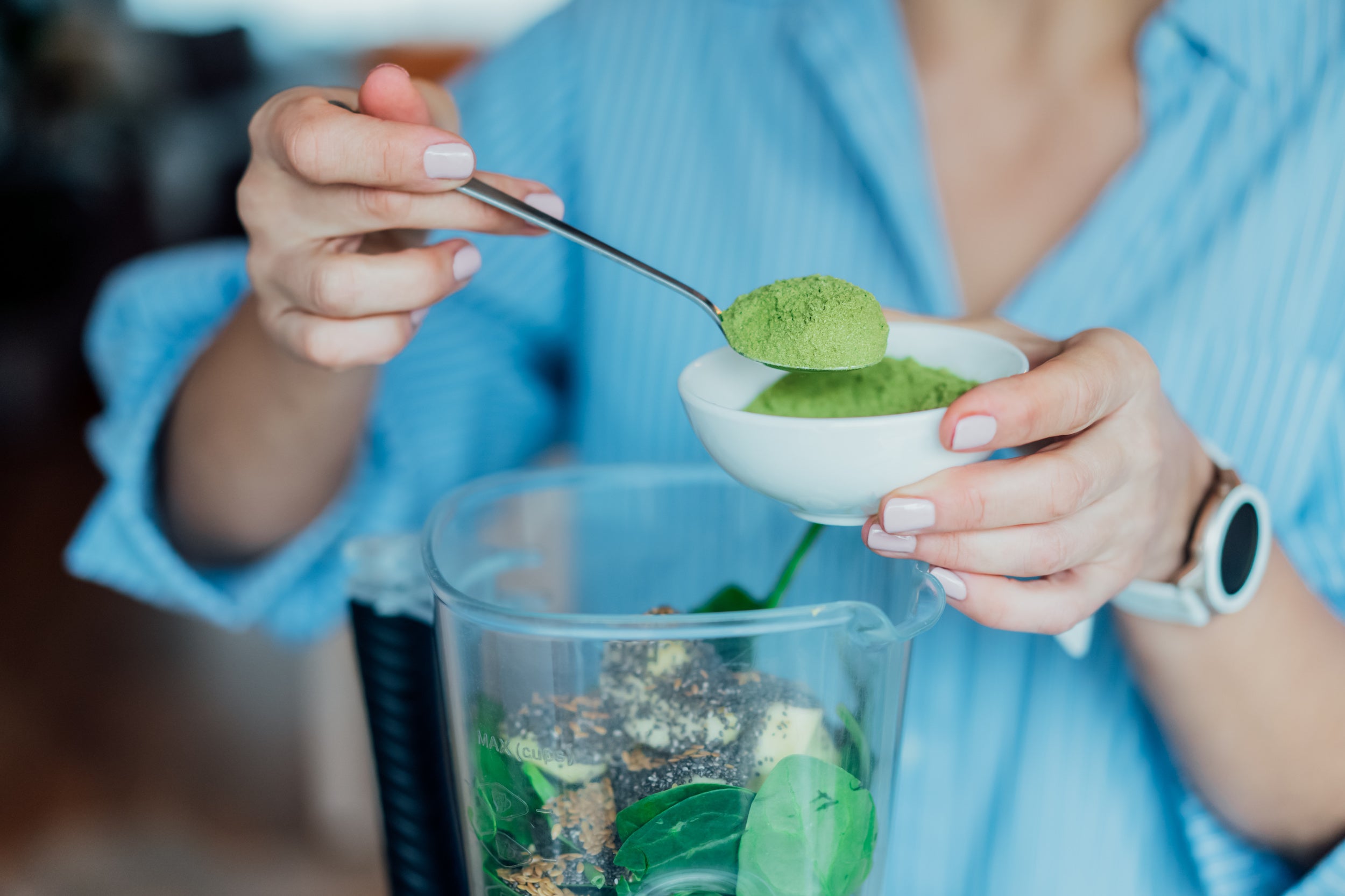 Image of someone mixing NutriFitt's Epic Greens into their morning smoothie.